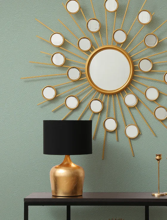 Décoration murale Terra en vert avec un miroir soleil et une lampe dorée